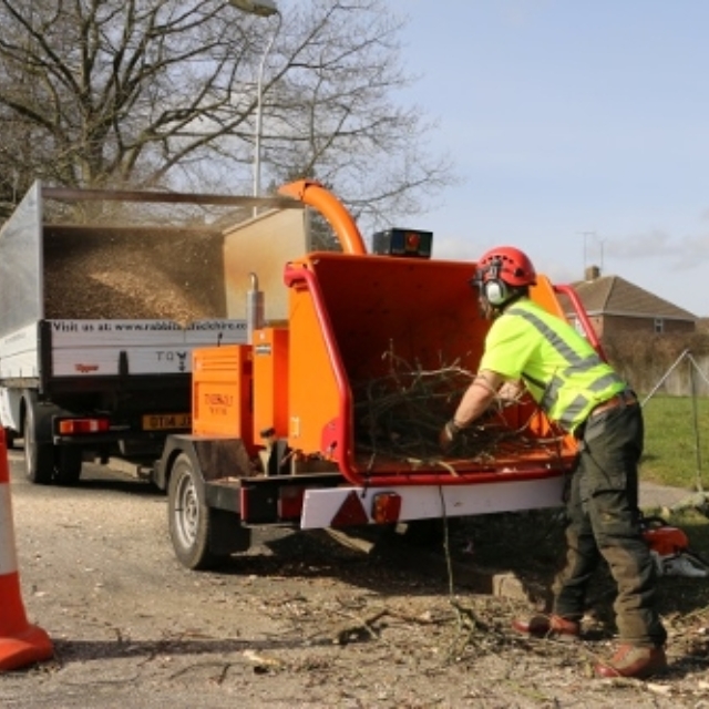 Member of commercial services team using a wood chipper