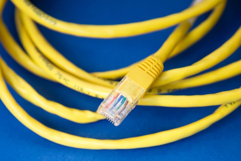 Yellow Ethernet cable on blue background