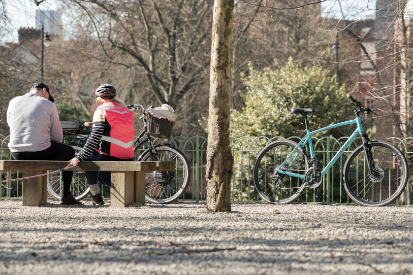 Cyclists sitting on a bench in Forbury Park, Reading
