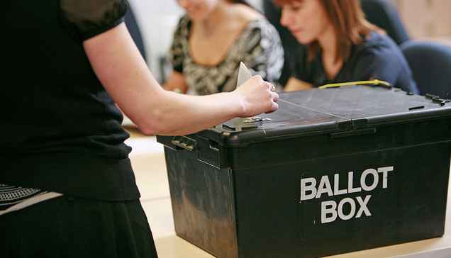 Someone posting their vote in a ballot box