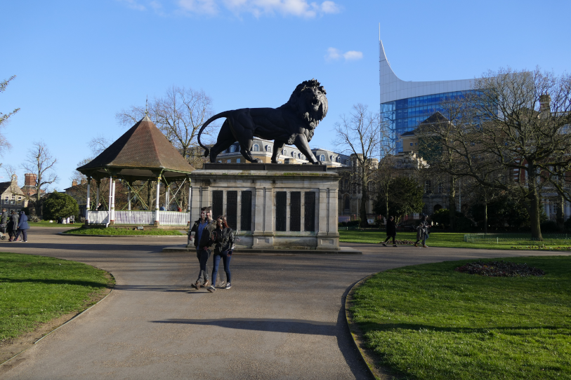 People walking by Maiwand lion at Forbury Park, Reading