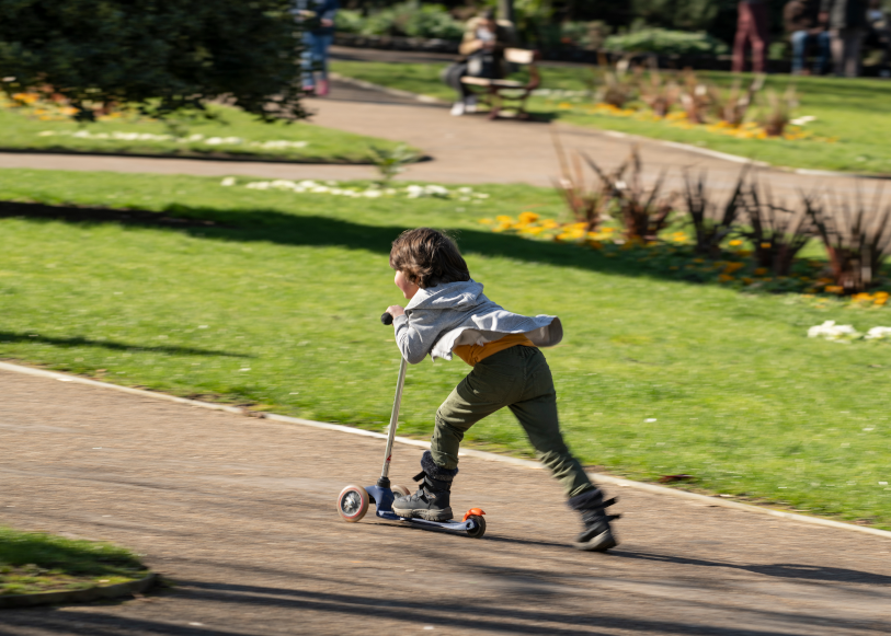 Little boy on a scooter in a park