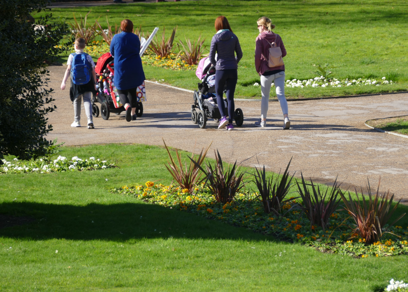 Family with buggies walking in Forbury park, Reading