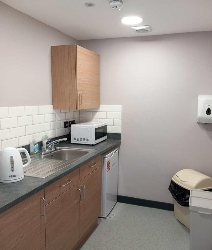 The kitchen has various amenities available such as a microwave, sink, kettle and fridge.