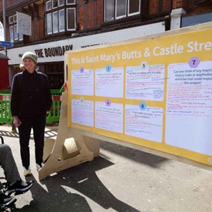 A woman is standing infront of the ideas board for Saint Mary's Butts & Castle Street.
