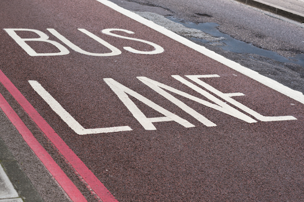 Bus lane marked with word 'Bus Lane' with double red lines.