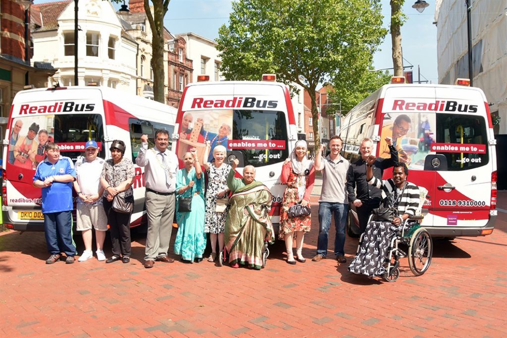 Three Readibuses parked on Broad Street with some passengers cheering.