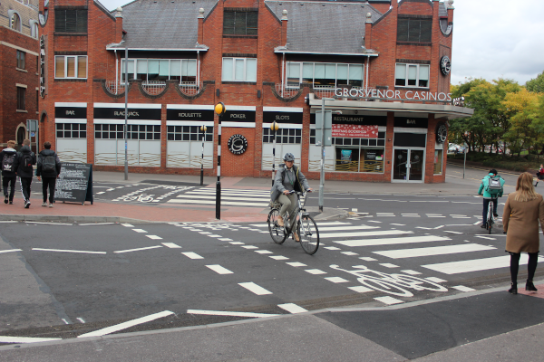 Cyclist on cycle crossing part of shared pedestrian/cycle crossing, heading towards the Oracle from London Street.