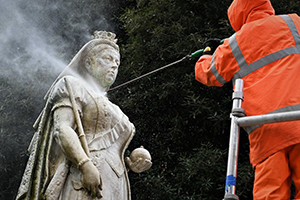 Photo of a council employee cleaning a statue