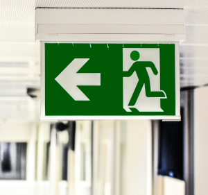 Exit sign hanging from a ceiling.