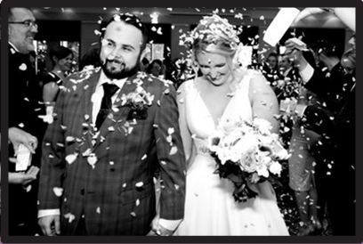 Bride and groom being showered with confetti.