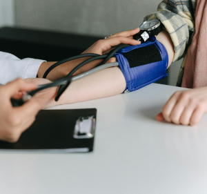 Shows arm of someone having their blood pressure taken.