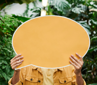 Giant speech bubble sticky note being held in front of a person.