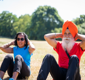 Older man and woman doing sit-ups.