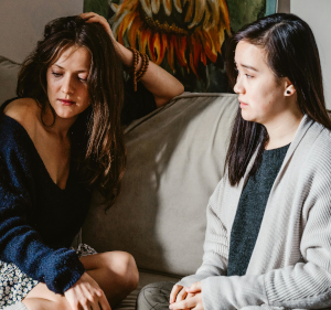 Two women sitting on a sofa.