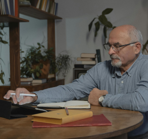 Man sat at a table with paperwork in front of him.