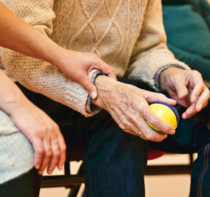 Elderly man's hands holding a ball.