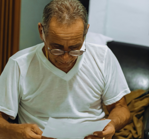 Man in t-shirt reading document.