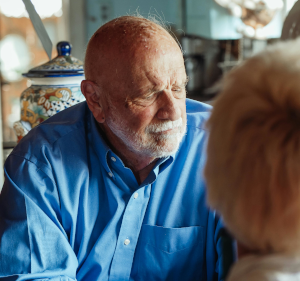 Man in blue shirt talking to someone.