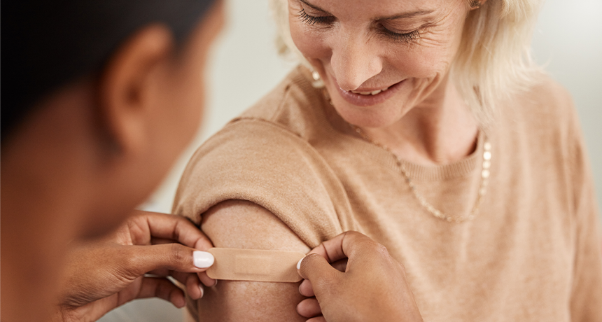 image of a woman having a plaster applied to her arm after having a vaccine