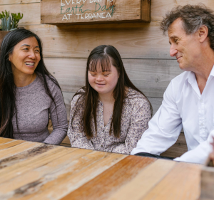 Girl with Down's syndrome sat with her parents.