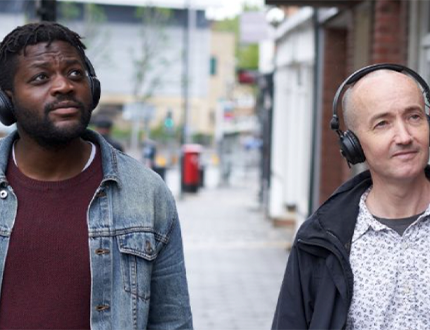 photo of two men with headphones on doing the audio trail