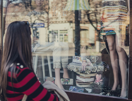 photo of a person looking into a shop window from a high street