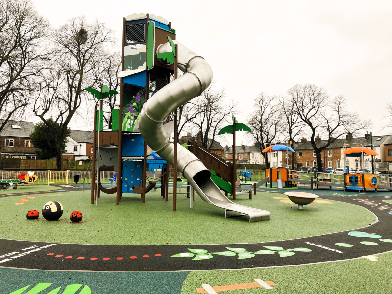 Playground photo includes a tall climbing town with silver tunnel slide