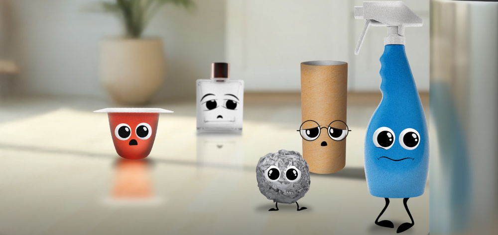 A collection of household cleaning and bathroom items with cartoon googly eyes and facial expressions arranged on a reflective surface. From left to right: a red cup or container with wide surprised eyes, a white rectangular bottle (possibly hand sanitizer or lotion) with droopy sad eyes, a small gray textured ball with cute round eyes and tiny legs, a brown cylindrical tube (likely cardboard packaging) wearing small round glasses with a neutral expression, and a blue spray bottle with large eyes and a slight smile, also with black stick legs. The background shows a blurred bathroom or kitchen setting with neutral tones.